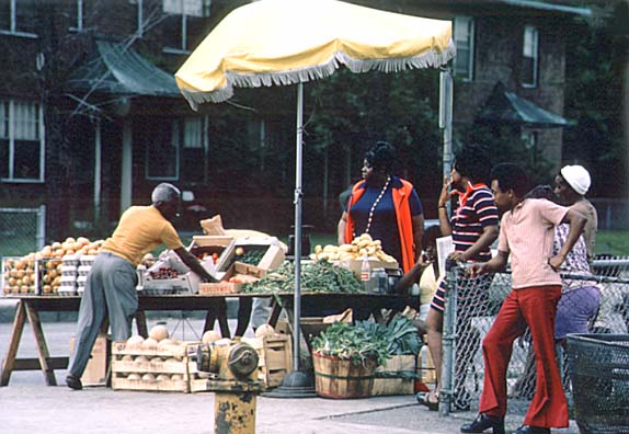 Black sidewalk salesmen arranging their fresh fruits and vegetables on Chicago's South Side. June 1973 (NWDNS-412-DA-13759)