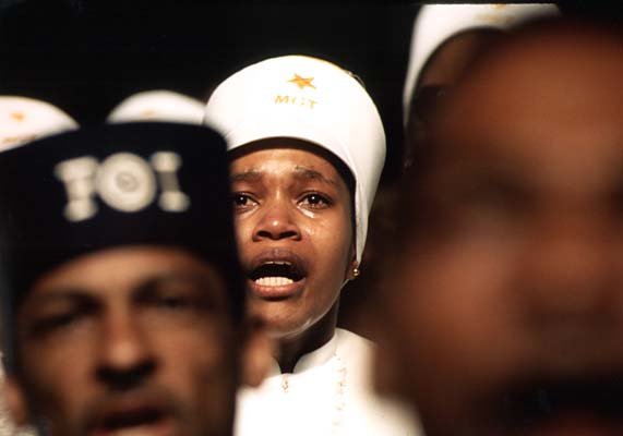 Religious fervor is mirrored on the face of a Black Muslim woman listening to Elijah Muhammad in Chicago. March 1974 (NWDNS-412-DA-13792)