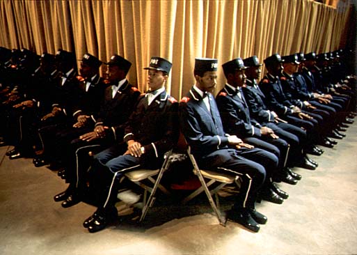 The Fruit of Islam, Elijah Muhammad's bodyguards, sit at the bottom of the platform while he delivers his annual Savior's Day message in Chicago. March 1974 (NWDNS-412-DA-13794)