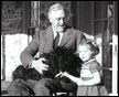 Franklin Delano Roosevelt in his Wheelchair with Fala and Ruthie Bie at Top Cottage, Hyde Park, New York, 02/1941. 