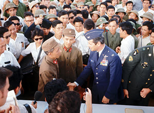 An unidentified U.S. Air Force Colonel, part of the prisoner of war returnee delegation, shakes hands with Vietnam officers