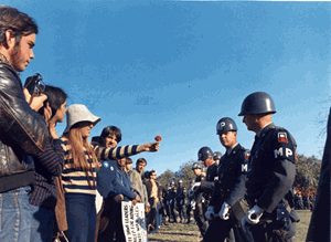 Photograph of a Female Demonstrator Offering a Flower to a Military Police Officer