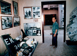 A Vietnamese visitor to Hanoi's Military Museum stands in a room with photographs and war memorabilia