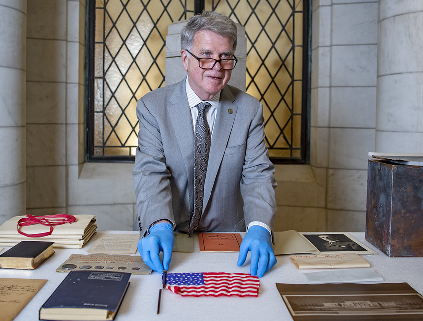Archivist David Ferrier looks at items in the Arlington Cemetery centennial time capsule