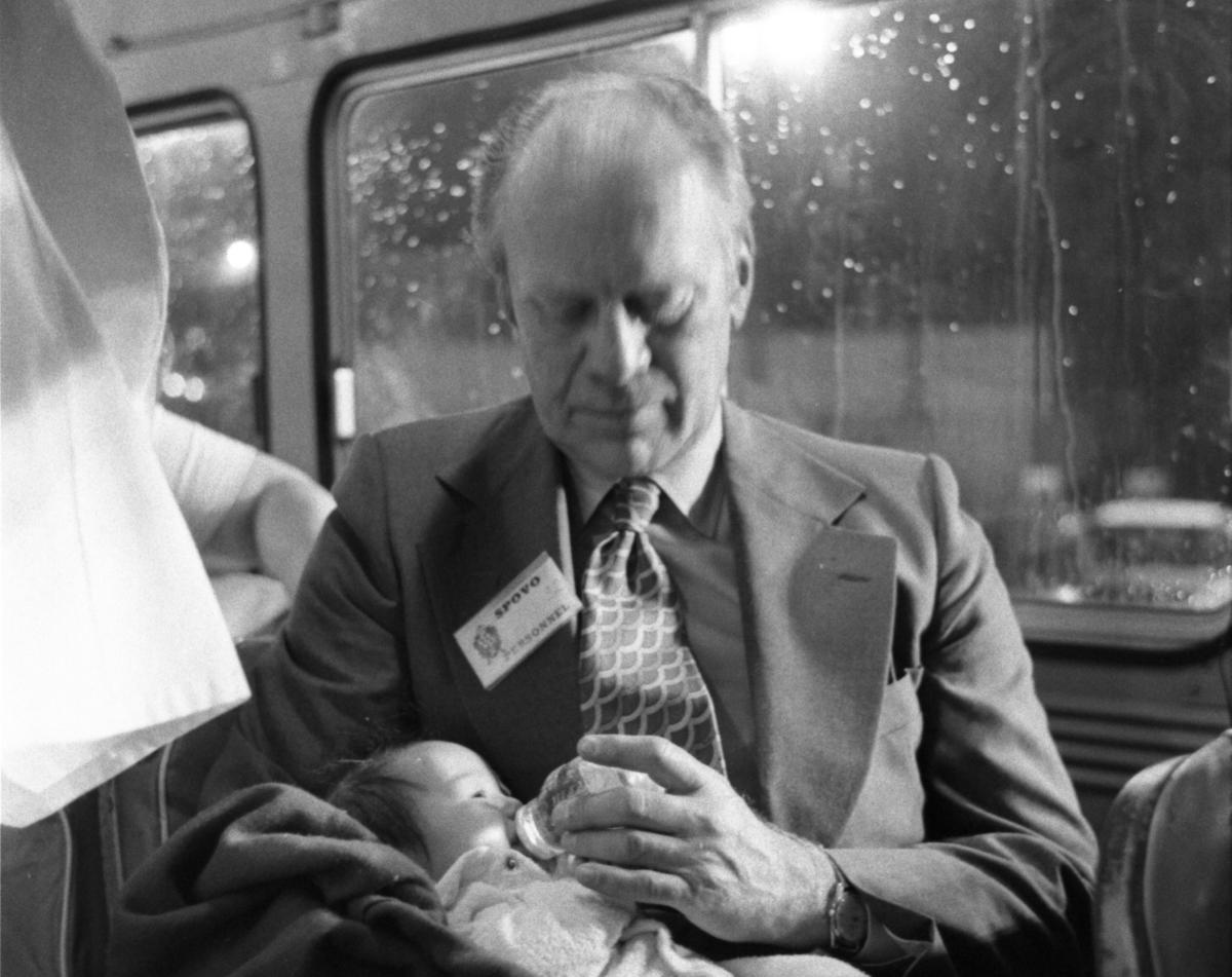 President Gerald R. Ford Holding a Refugee Baby on an Evacuation Bus at San Francisco International Airport Following the Arrival of an Operation Babylift Plane from South Vietnam